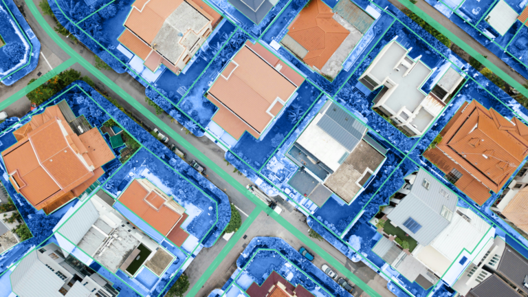 Imagem aérea de uma área residencial, destacando diversos tipos de edificações, muros, calçadas e ruas.